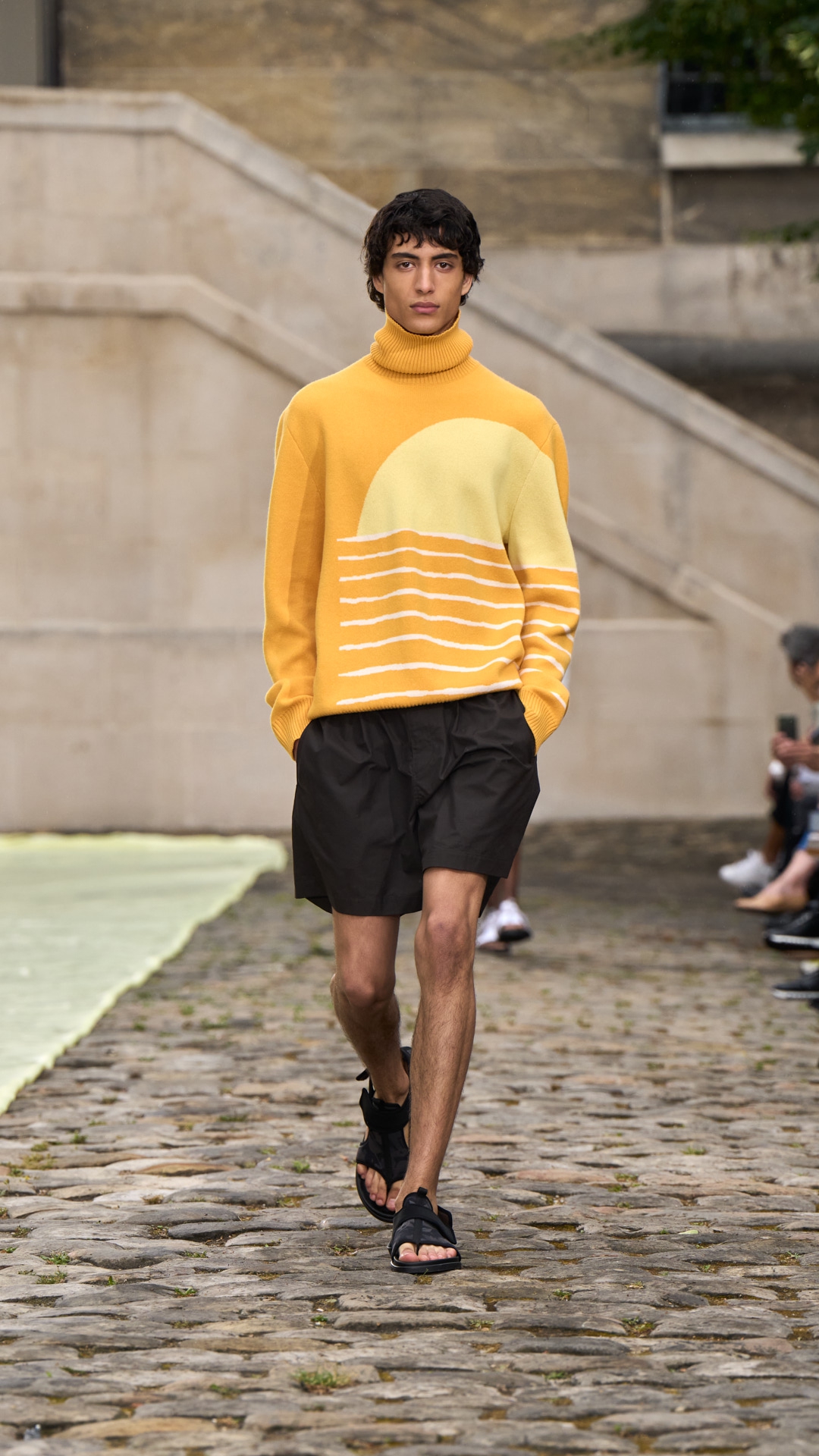 Model mengenakan sweter kuning Hermes