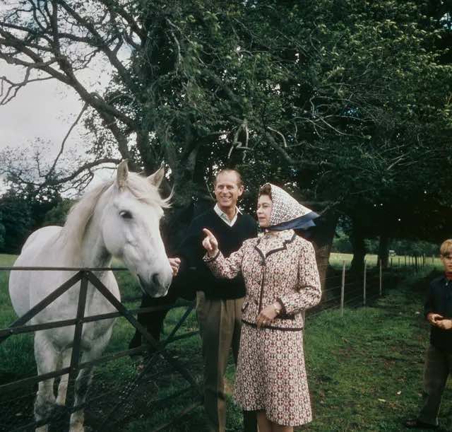 (Ratu Elizabeth II bersama Pangeran Philip sedang mengamati seekor kuda di perkebunan Balmoral pada tahun 1972.)
