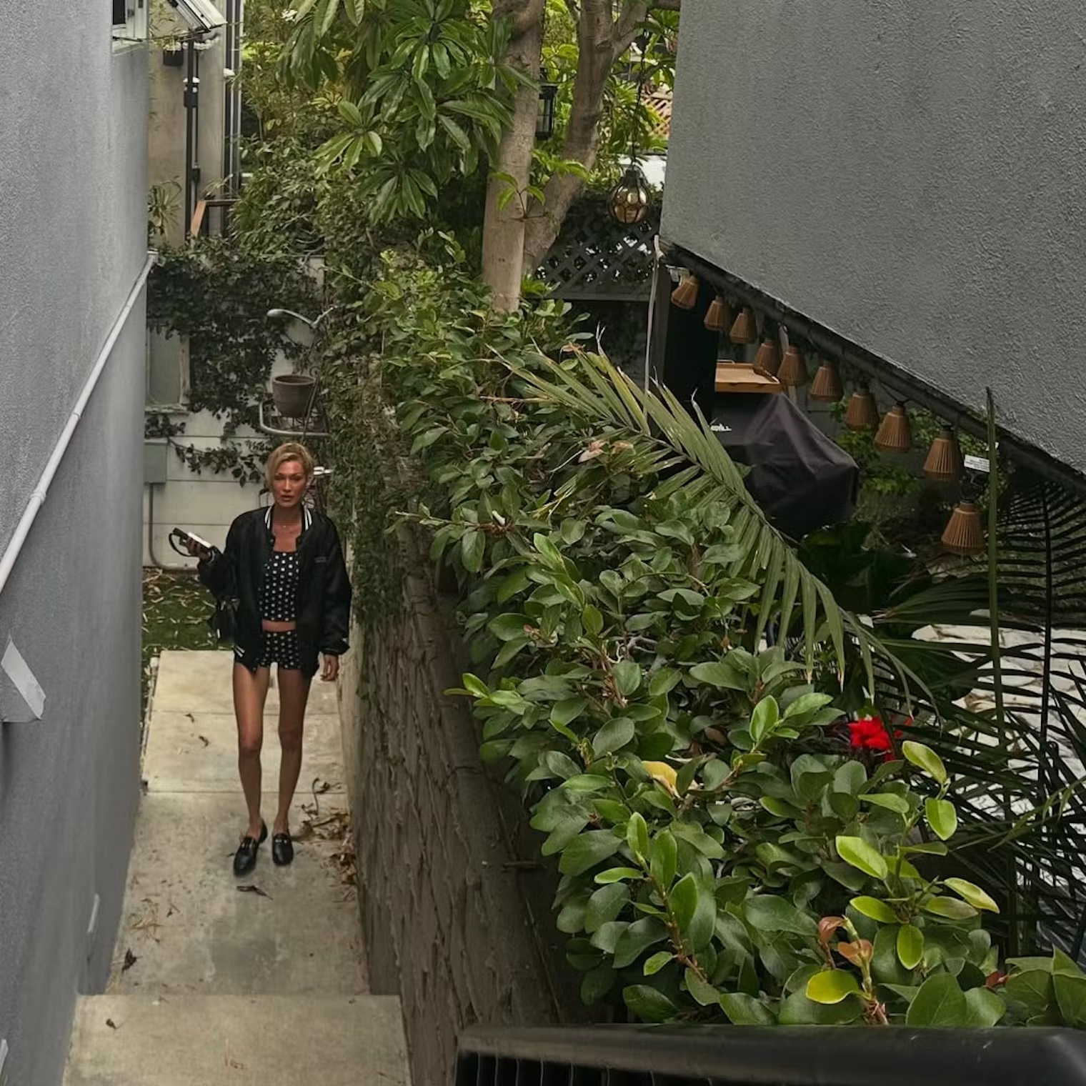 Bella Hadid Memakai Set Celana Pendek Mikro Bermotif Polka-Dot dan Jaket Varsity