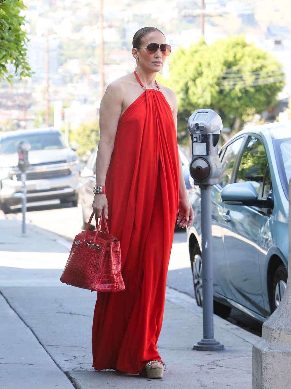 Tampilan Serasi Jennifer Lopez Dalam Gaun Maxi Merah dan Tas Herm&egrave;s Birkin