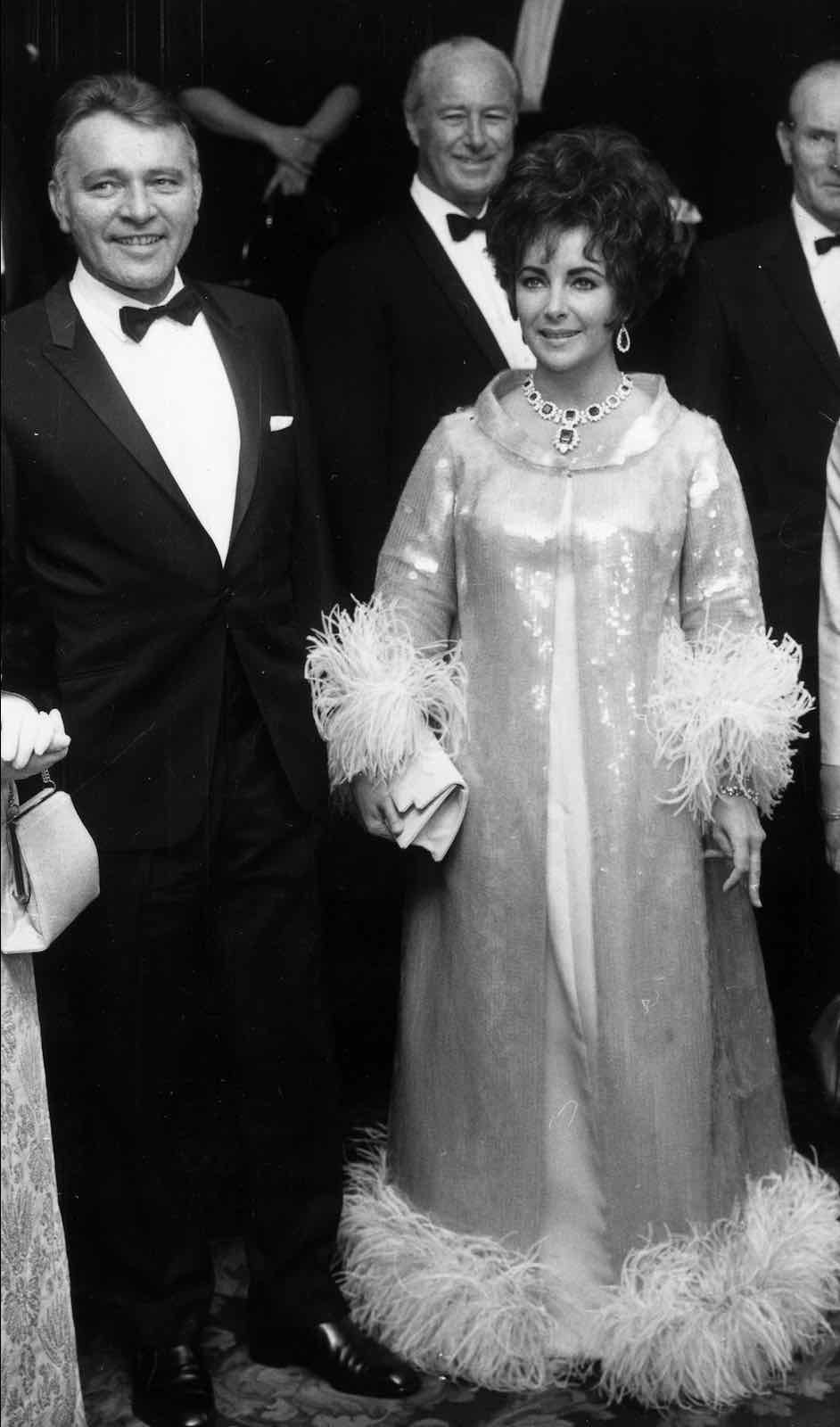 (Elizabeth Taylor tampil dalam perhiasan Bulgari emerald dan diamond suite ketika menghadiri BAFTA tahun 1967 bersama dengan Richard Burton)