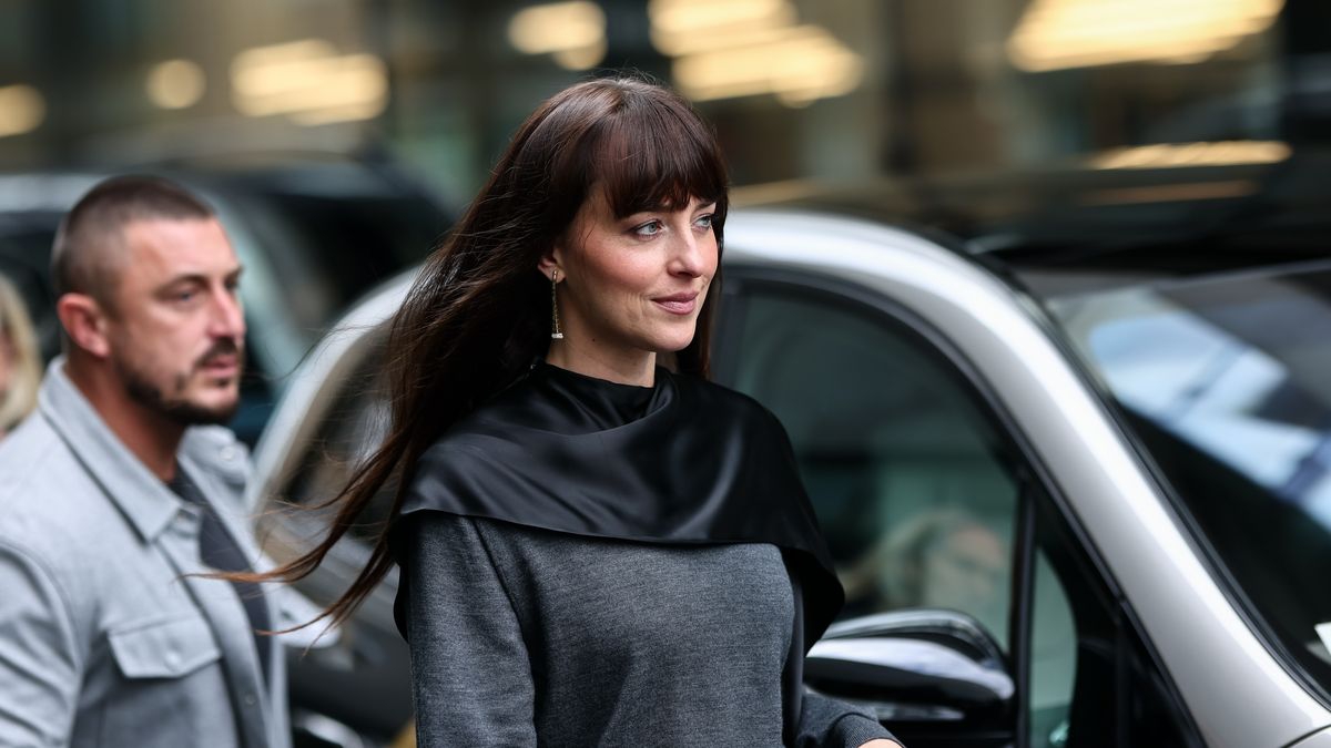 Dakota Johnson Tampil Manis dan Keren dengan Platform Boots Kulit dan Cape Sweater