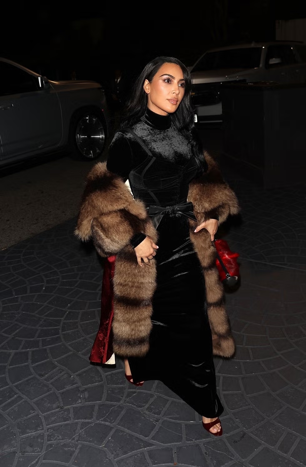 Kim Kardashian Tampil Klasik dalam Gaun Beludru Hitam Beraksen Satin Merah dan Stole Bulu
