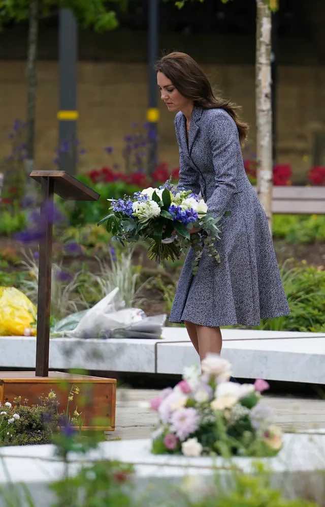 (Duchess Kate menaruh bunga di acara memorial.)