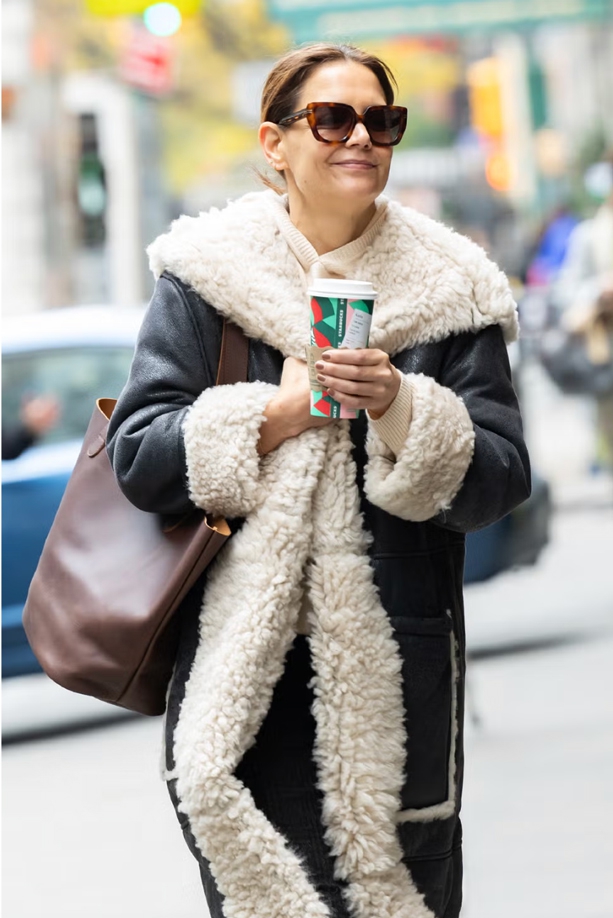 Katie Holmes Tampil Hangat dengan Mantel Shearling Hitam-Putih Besar