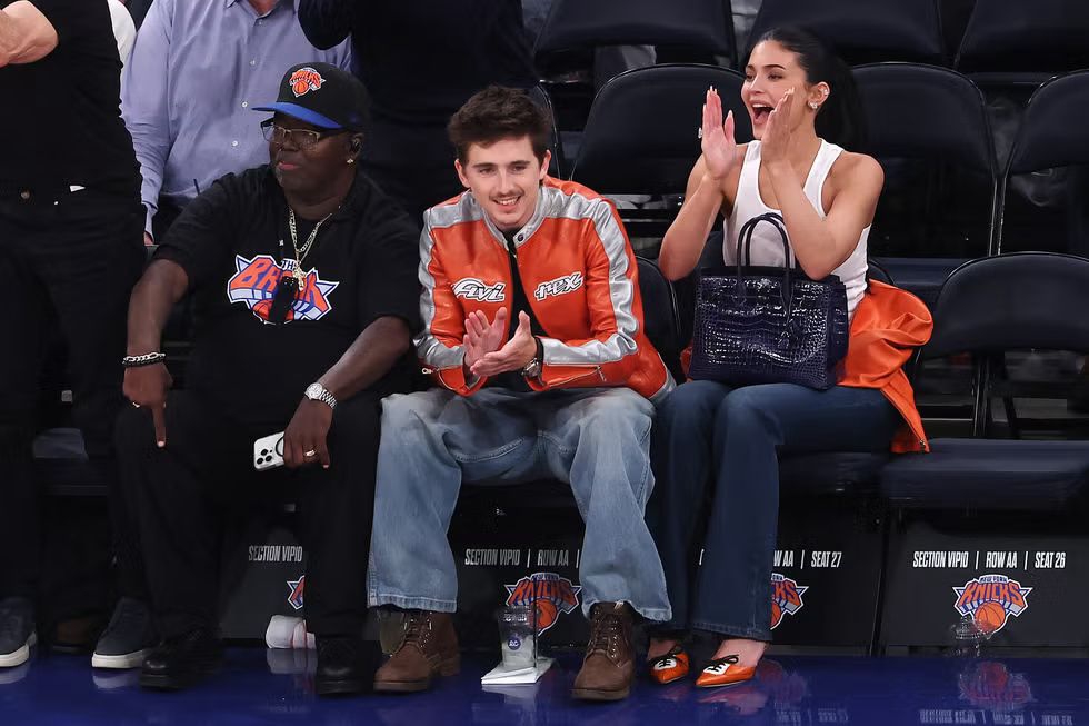 Penampilan Kylie Jenner Saat Kencan di Pinggir Lapangan? Sepatu Mules Miu Miu Berwarna Oranye Knicks, dan Tas Birkin Kulit Buaya Berwarna Biru Knicks