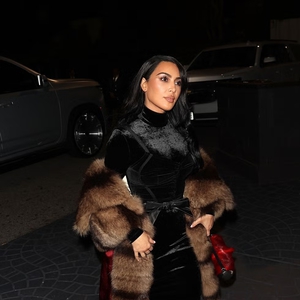 Kim Kardashian Tampil Klasik dalam Gaun Beludru Hitam Beraksen Satin Merah dan Stole Bulu