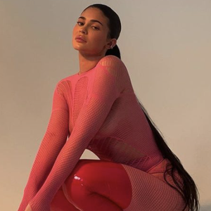 Kylie Jenner Memadukan Fishnet Catsuit Berwarna Hot Pink dengan Sepatu Bot Setinggi Paha