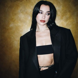 Dua Lipa Memamerkan Otot Perutnya dengan Belly Chain Berornamen, Bralette, dan Blazer Oversized