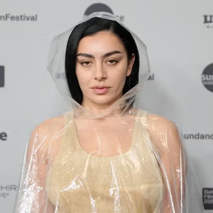 Charli XCX Kenakan Terusan Nude dengan Ponco Transparan Berhiaskan Renda