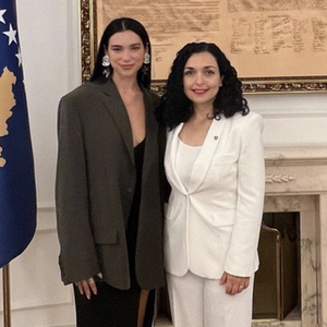 Gaya Fashion Bisnis Ala Dua Lipa Mencakup Gaun Belahan Tinggi dan Anting Menawan