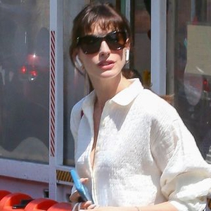 Anne Hathaway Memadukan Atasan Oversized dengan Celana Pendek Berwarna Krem
