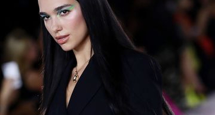 Gaya Preppy Dua Lipa dengan Rompi Sweater Gucci dan Blazer Pinstripe