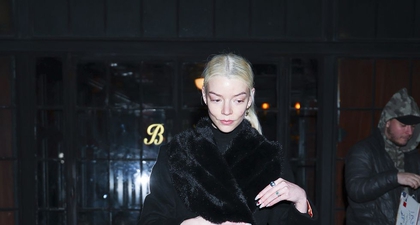 Anya Taylor-Joy Memakai Mantel Hitam yang Menampilkan Warna Oranye