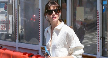 Anne Hathaway Memadukan Atasan Oversized dengan Celana Pendek Berwarna Krem